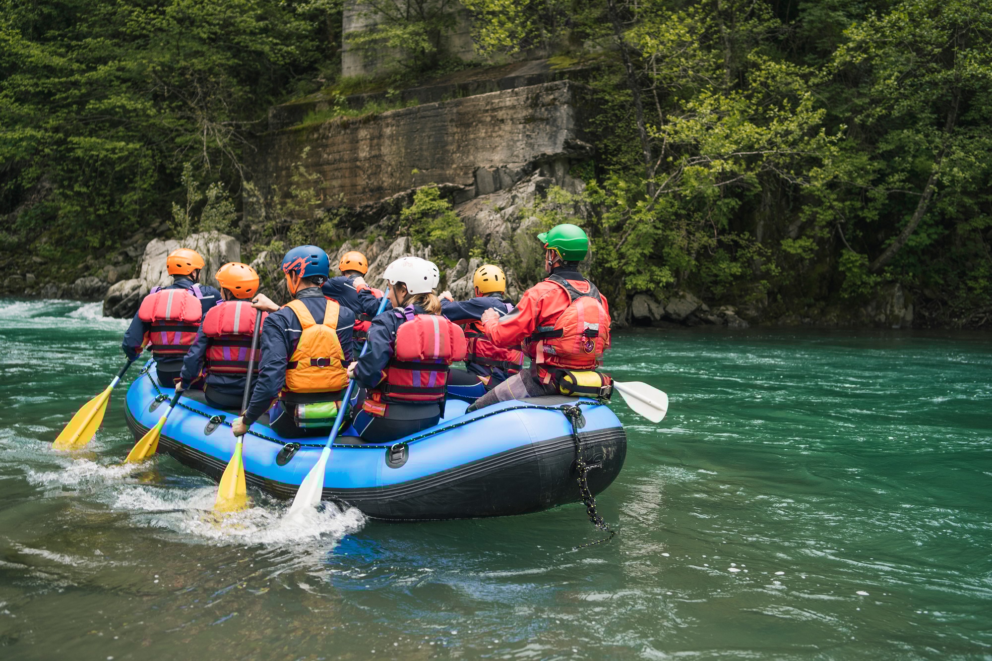Group of people rafting in rubber dinghy on a river